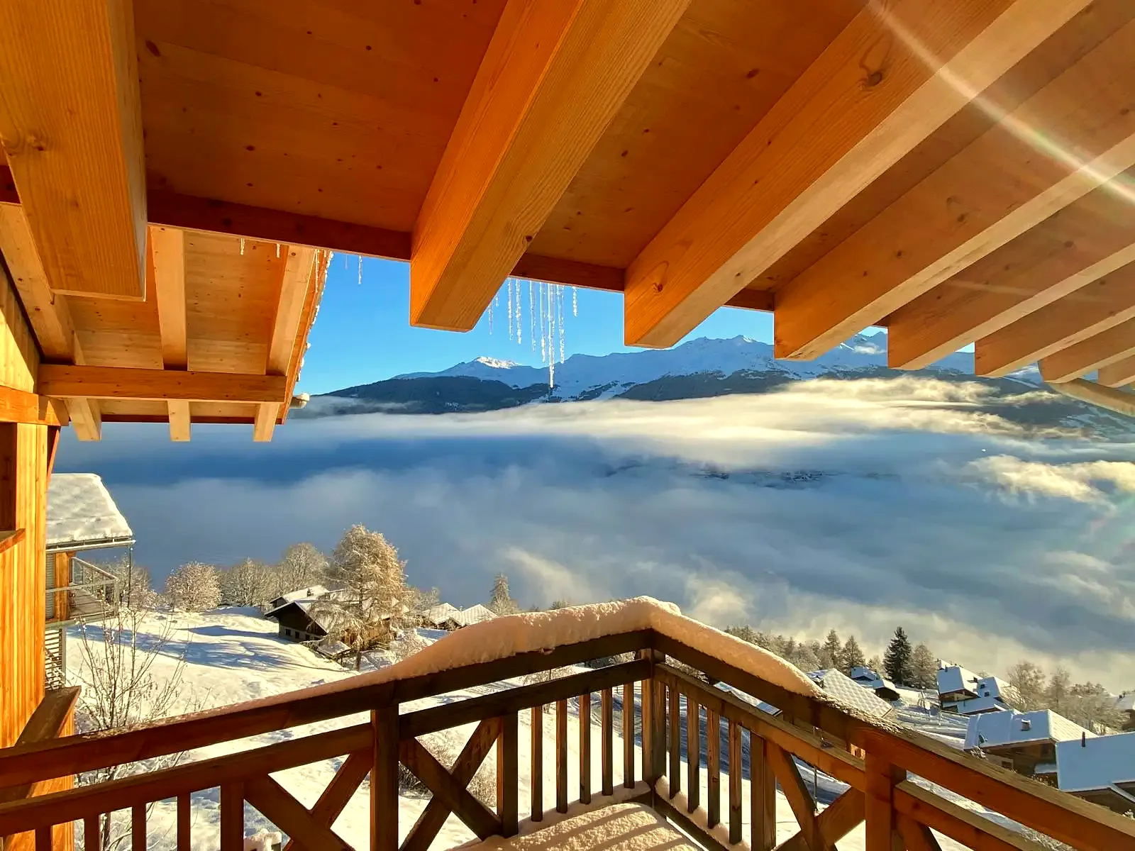 L’avant-toit du chalet au soleil, au-dessus des nuages